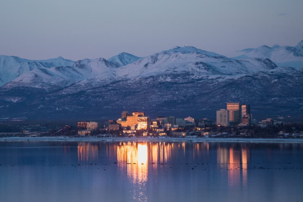 Anchorage skyline framed by the Chugach Mountains at dusk